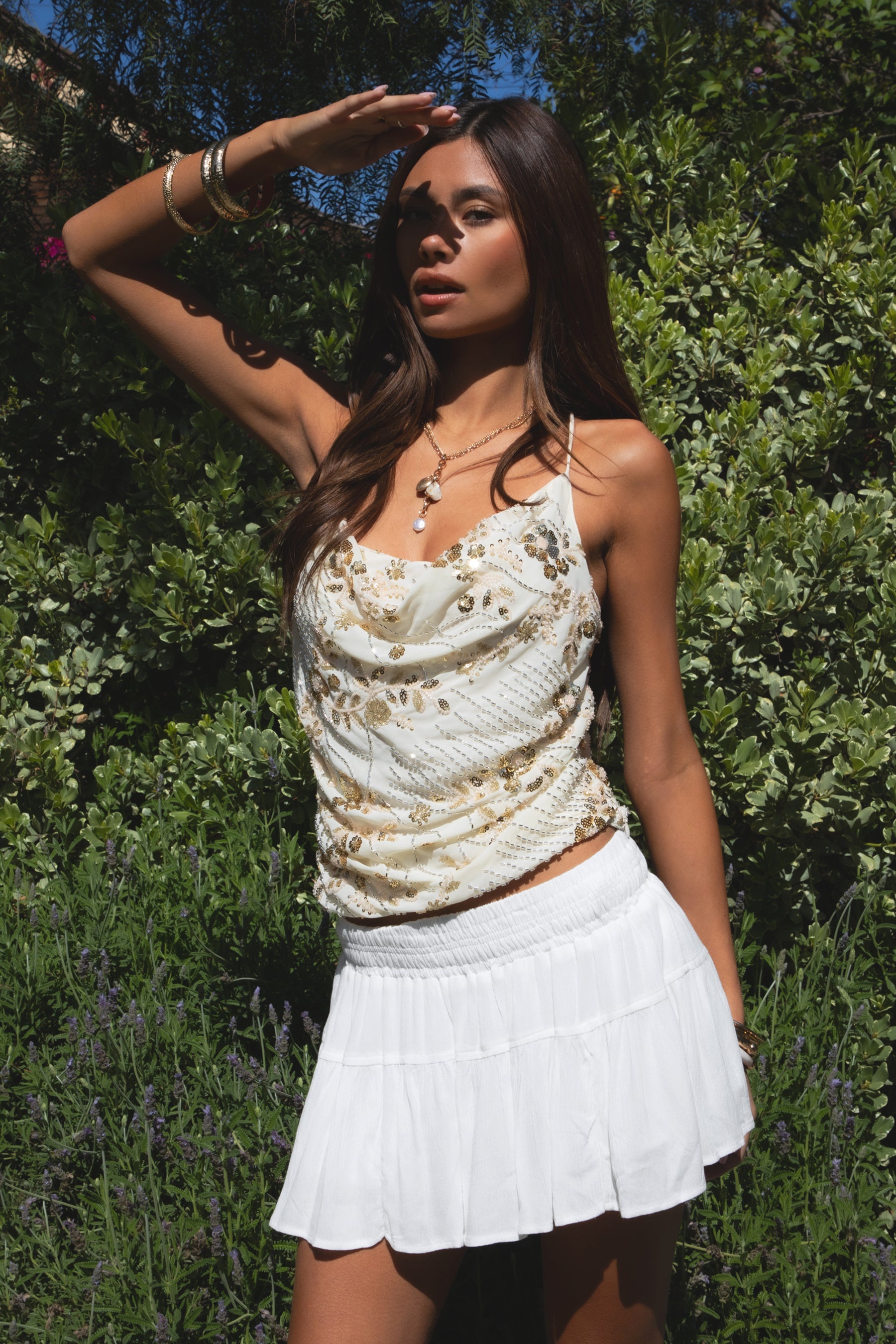 Woman wearing TIC TOC TL31684 AURYA chiffon sequin beaded cowl neck top featuring a draped cowl neckline, floral sequin and beaded embroidery, thin adjustable straps with cross back detail, fitted cropped silhouette, and asymmetrical hemline for a feminine festival and night-out look.
