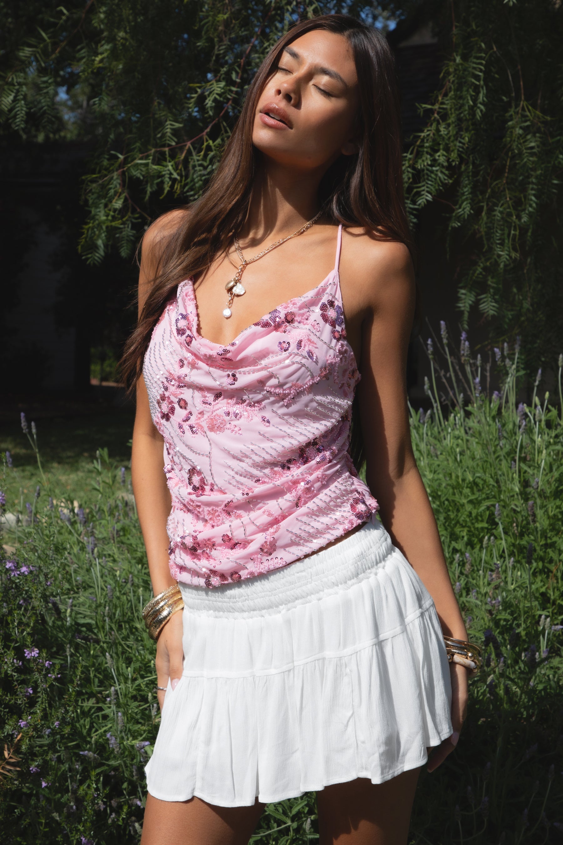 Woman wearing TIC TOC TL31684 AURYA chiffon sequin beaded cowl neck top featuring a draped cowl neckline, floral sequin and beaded embroidery, thin adjustable straps with cross back detail, fitted cropped silhouette, and asymmetrical hemline for a feminine festival and night-out look.