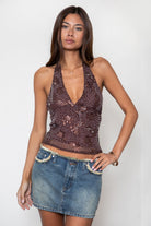 Woman wearing TIC TOC TL31688 VESTRA sequin beaded mesh halter top featuring sheer mesh fabric with floral sequin and beaded embroidery, a deep V-neckline with halter tie, fitted silhouette, open back with adjustable self-tie closure, and a fully lined interior for a bold festival and night-out look.