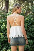 Woman wearing TIC TOC TL31885 ALUME gauze embroidery babydoll top featuring lightweight cotton gauze fabric, a V neckline with embroidered bust detail, scalloped eyelet hem with floral embroidery, elastic under bust shaping, and thin adjustable cross back straps for a soft feminine summer look.