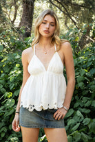 Woman wearing TIC TOC TL31885 ALUME gauze embroidery babydoll top featuring lightweight cotton gauze fabric, a V neckline with embroidered bust detail, scalloped eyelet hem with floral embroidery, elastic under bust shaping, and thin adjustable cross back straps for a soft feminine summer look.