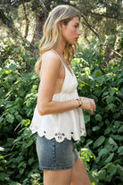 Woman wearing TIC TOC TL31885 ALUME gauze embroidery babydoll top featuring lightweight cotton gauze fabric, a V neckline with embroidered bust detail, scalloped eyelet hem with floral embroidery, elastic under bust shaping, and thin adjustable cross back straps for a soft feminine summer look.