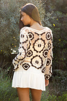 Woman wearing TIC TOC TL31962-SOLANDRA SOLANDRA crochet long sleeve cover up top featuring an open crochet mandala flower pattern in contrast cream and brown circular design, wide round neckline, relaxed easy fit silhouette, and long bell sleeves with lightweight open knit texture, styled over a simple bralette and bottoms for a boho festival and resort-ready look.