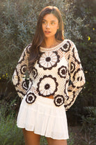 Woman wearing TIC TOC TL31962-SOLANDRA SOLANDRA crochet long sleeve cover up top featuring an open crochet mandala flower pattern in contrast cream and brown circular design, wide round neckline, relaxed easy fit silhouette, and long bell sleeves with lightweight open knit texture, styled over a simple bralette and bottoms for a boho festival and resort-ready look.