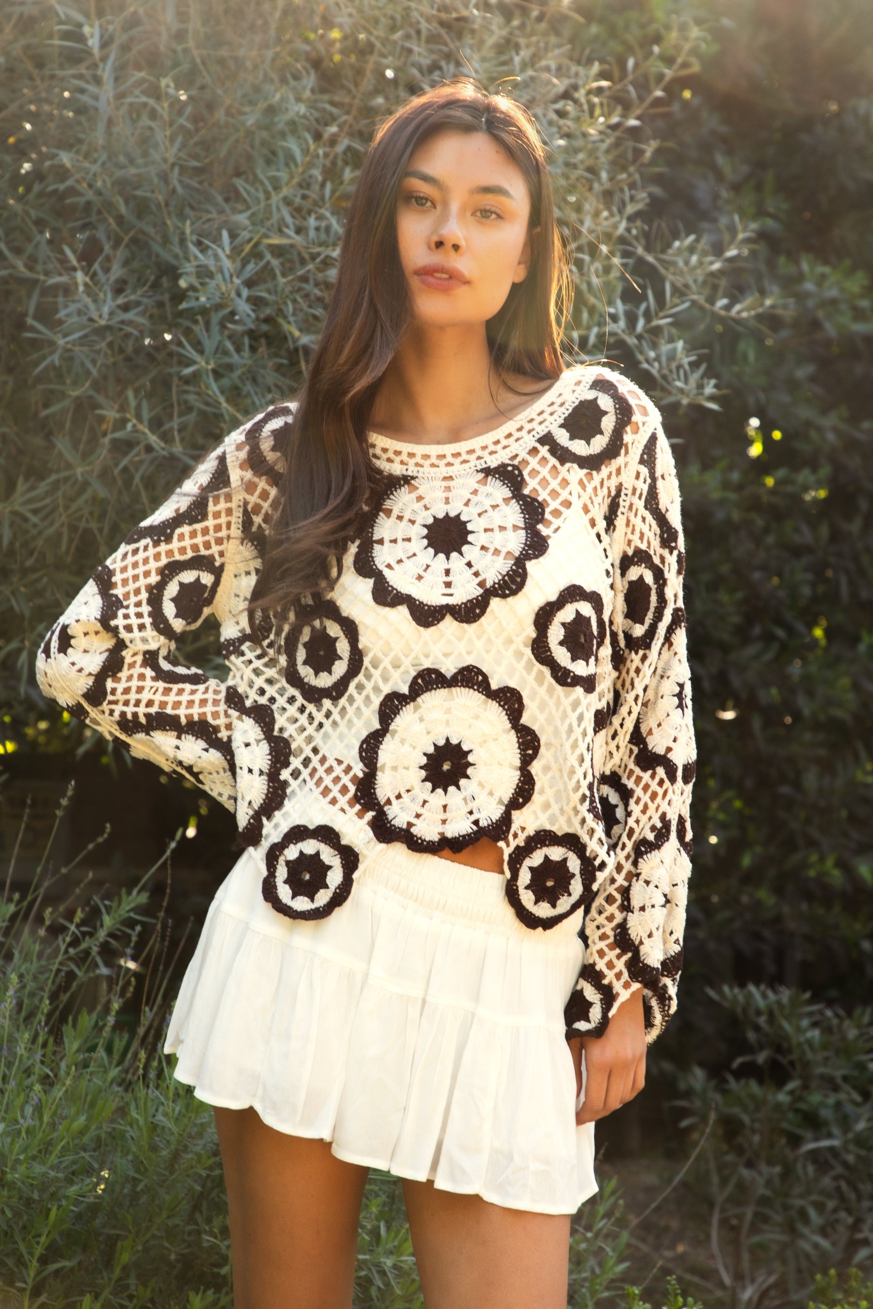 Woman wearing TIC TOC TL31962-SOLANDRA SOLANDRA crochet long sleeve cover up top featuring an open crochet mandala flower pattern in contrast cream and brown circular design, wide round neckline, relaxed easy fit silhouette, and long bell sleeves with lightweight open knit texture, styled over a simple bralette and bottoms for a boho festival and resort-ready look.