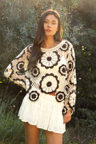 Woman wearing TIC TOC TL31962-SOLANDRA SOLANDRA crochet long sleeve cover up top featuring an open crochet mandala flower pattern in contrast cream and brown circular design, wide round neckline, relaxed easy fit silhouette, and long bell sleeves with lightweight open knit texture, styled over a simple bralette and bottoms for a boho festival and resort-ready look.