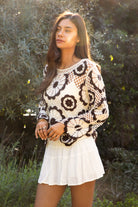 Woman wearing TIC TOC TL31962-SOLANDRA SOLANDRA crochet long sleeve cover up top featuring an open crochet mandala flower pattern in contrast cream and brown circular design, wide round neckline, relaxed easy fit silhouette, and long bell sleeves with lightweight open knit texture, styled over a simple bralette and bottoms for a boho festival and resort-ready look.