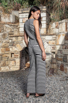Woman wearing MONACO stripe novelty sleeveless vest knit set featuring textured stripe novelty knit fabric, sleeveless button front peplum top, matching high waisted wide leg pants, functional front and back patch pockets, and an easy pull on design for resort and everyday styling.