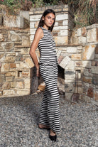 Woman wearing MONACO stripe novelty sleeveless vest knit set featuring textured stripe novelty knit fabric, sleeveless button front peplum top, matching high waisted wide leg pants, functional front and back patch pockets, and an easy pull on design for resort and everyday styling.