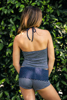 Woman wearing MISTY stripe polka dot short and tank set featuring a square neck sleeveless tank top with self tie halter neck strap, contrast stripe and polka dot design, fold over waist shorts, and soft stretch jersey fabric for relaxed lounge and coastal styling.