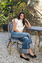 Woman wearing GARANCE mock neck sleeveless sweater top featuring a soft fuzzy knit texture, clean minimalist silhouette, polished mock neckline, relaxed bodice, subtle extended shoulder design, cropped length, wide ribbed hem, and solid color design for easy transitional layering.