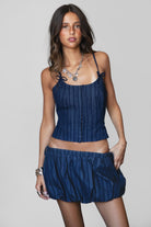 MANON Stripped Stretch Denim Skirt Set 
Denim Bustier Top 
Low Scoop Neckline 
Exposed Self Bow Detail 
Adjustable Shoulder Straps 
Adjustable Lace Up Tie At Center Back 
Hidden Zipper Closure At Side 
Matching Low Rise Mini Skirt 
Stretch Waistband
Built In Under Shorts
