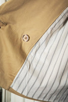 Woman wearing TIC TOC TT31828-MARAIS MARAIS oversized long sleeve cropped trench jacket featuring a double breasted front button closure, drop shoulder long sleeves with adjustable sleeve straps, removable thick self tie waist strap, and two loop holes on the back, finished with stripe voile lining inside, styled over a simple top and tailored bottoms for a Parisian chic, western-minimal layered look.