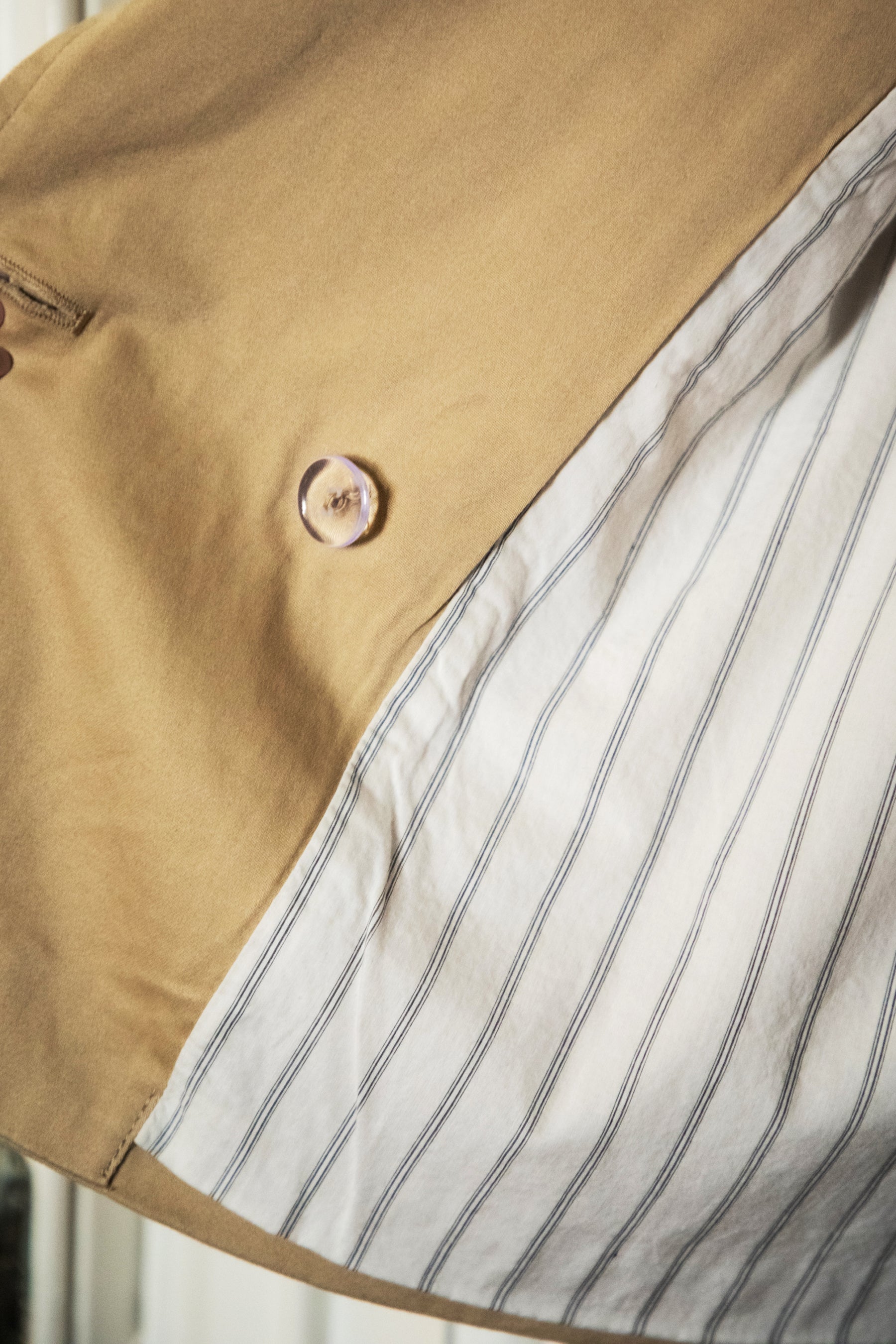 Woman wearing TIC TOC TT31828-MARAIS MARAIS oversized long sleeve cropped trench jacket featuring a double breasted front button closure, drop shoulder long sleeves with adjustable sleeve straps, removable thick self tie waist strap, and two loop holes on the back, finished with stripe voile lining inside, styled over a simple top and tailored bottoms for a Parisian chic, western-minimal layered look.