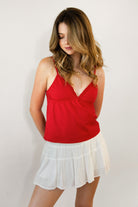 Woman wearing LEMONY cotton jersey lace trim cami top featuring a soft V-neckline with delicate ruffle trim, adjustable spaghetti straps, empire seam detail, and lightweight cotton jersey fabric with comfortable stretch for everyday layering and lounge styling.