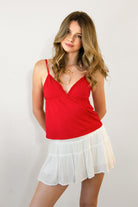 Woman wearing LEMONY cotton jersey lace trim cami top featuring a soft V-neckline with delicate ruffle trim, adjustable spaghetti straps, empire seam detail, and lightweight cotton jersey fabric with comfortable stretch for everyday layering and lounge styling.