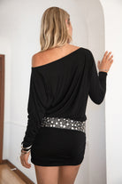 Woman wearing a black off-shoulder dress with a silver belt.