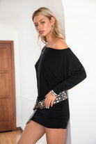 Woman wearing a black off-shoulder dress with a silver belt.