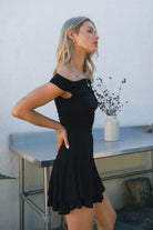 Woman wearing TIC TOC DC31642BA RAVAYA off-the-shoulder mini dress featuring ruched sides and a frill hemline in soft rayon spandex fabric