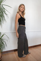 Woman wearing a black tank top and TIC TOC PH29257 ARROW charcoal twill carpenter cargo pants featuring multiple utility pockets and straight-leg fit.