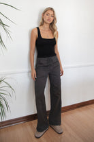 Woman wearing a black tank top and TIC TOC PH29257 ARROW charcoal twill carpenter cargo pants featuring multiple utility pockets and straight-leg fit.