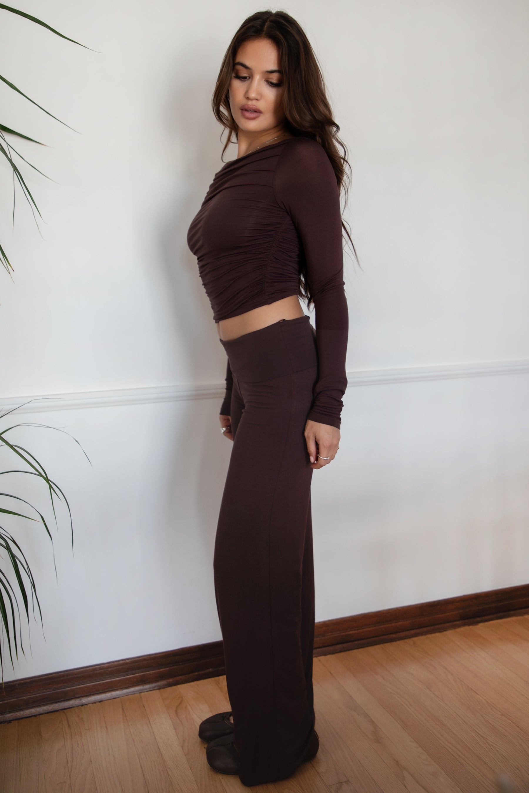 Woman wearing the TIC TOC PH31588BA SORA brown fold over straight leg leggings featuring a low rise waistline, smooth stretch fabric, and straight leg finish with the matching top against a white wall.