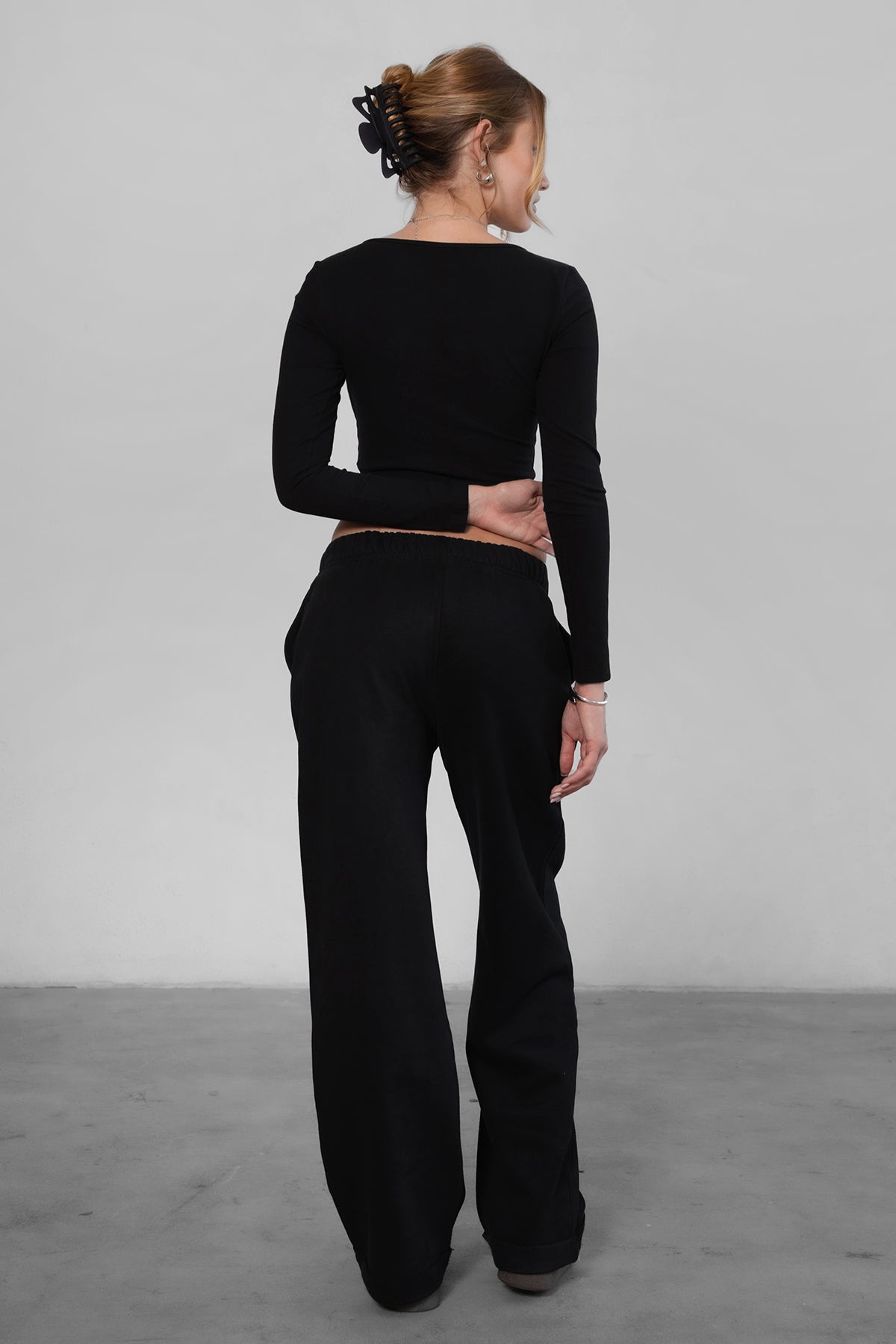 Woman wearing the TIC TOC PJ30241 LANI black cloud fleece wide leg sweatpants featuring a straight leg silhouette, drawcord waistband, and side pockets paired with a matching sweater.