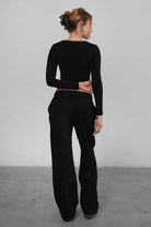 Woman wearing the TIC TOC PJ30241 LANI black cloud fleece wide leg sweatpants featuring a straight leg silhouette, drawcord waistband, and side pockets paired with a matching sweater.