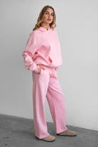 Woman wearing the TIC TOC PJ30241 LANI blush cloud fleece wide leg sweatpants featuring a straight leg silhouette, drawcord waistband, and side pockets paired with a matching sweater.