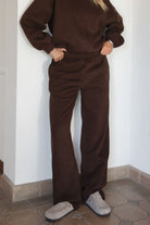 Woman wearing the TIC TOC PJ30241 LANI brown cloud fleece wide leg sweatpants featuring a straight leg silhouette, drawcord waistband, and side pockets paired with a matching hoodie. 