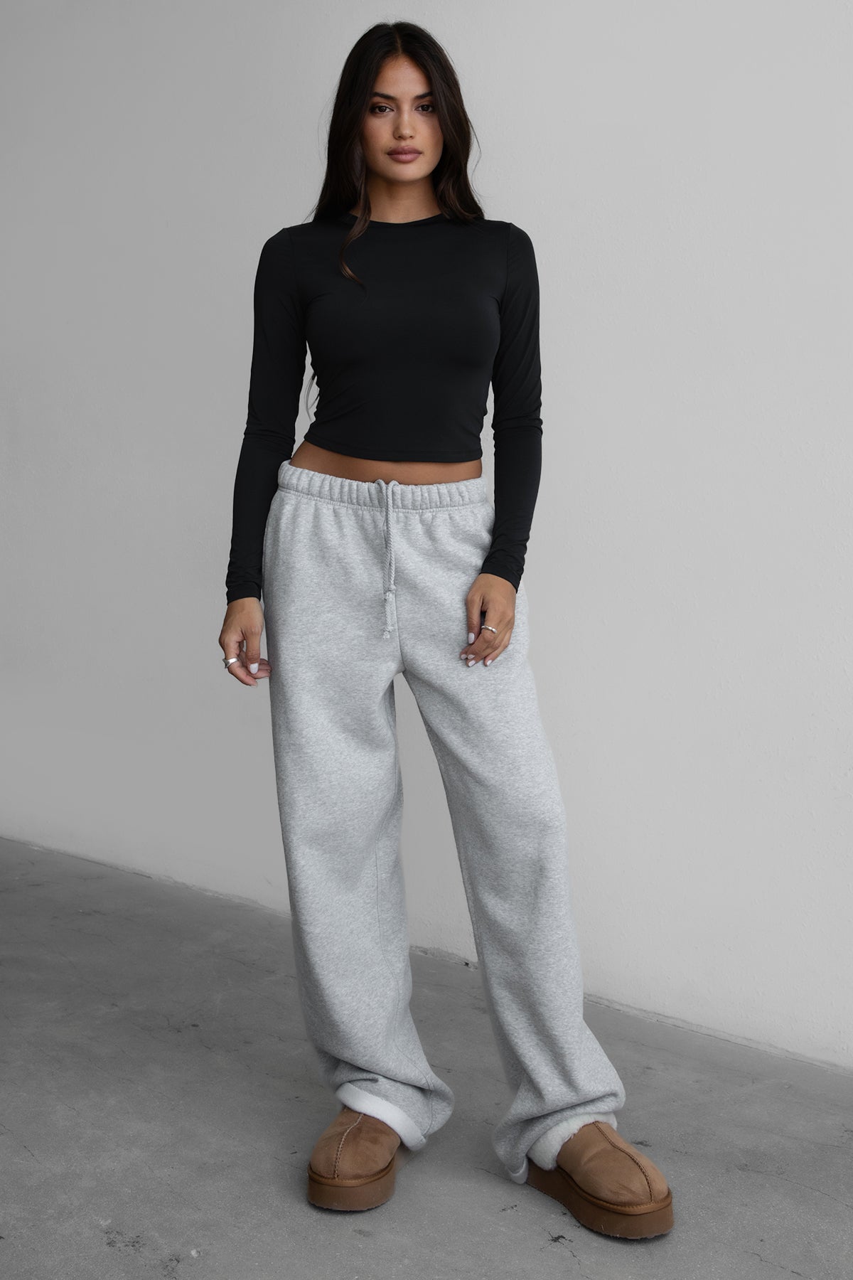 Woman wearing the TIC TOC PJ30241 LANI heather grey cloud fleece wide leg sweatpants featuring a straight leg silhouette, drawcord waistband, and side pockets paired with a matching sweater.