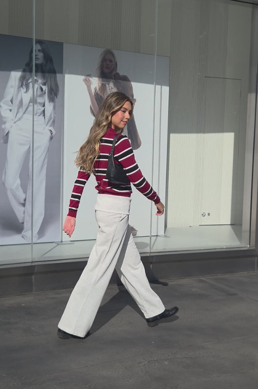 woman wearing TIC TOC TC30738 RHODES striped polo T-shirt featuring a relaxed collar, quarter button-up closure, multicolor stripe pattern, and smooth sweater knit texture styled casually with denim in an outdoor lifestyle setting.