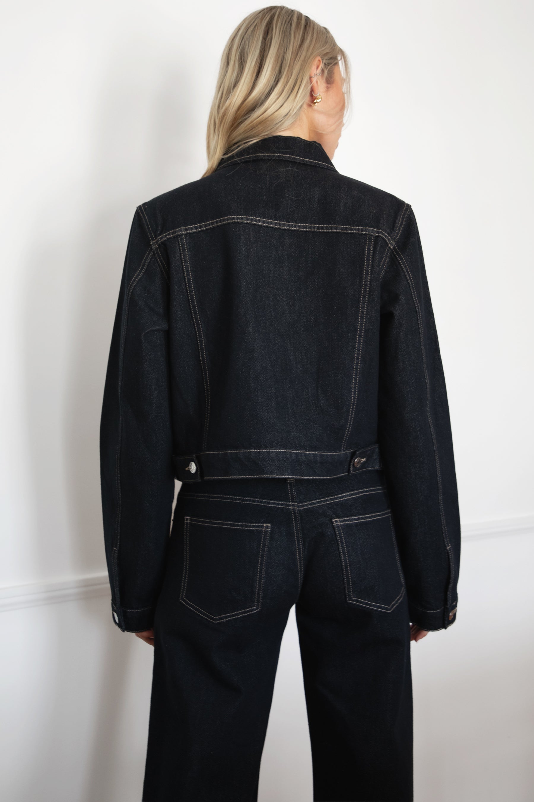 Model wearing TIC TOC TF31704 MILLS  selvedge denim jacket in dark blue wash with structured fit and contrast stitching with matching denim jeans in an indoor setting. 