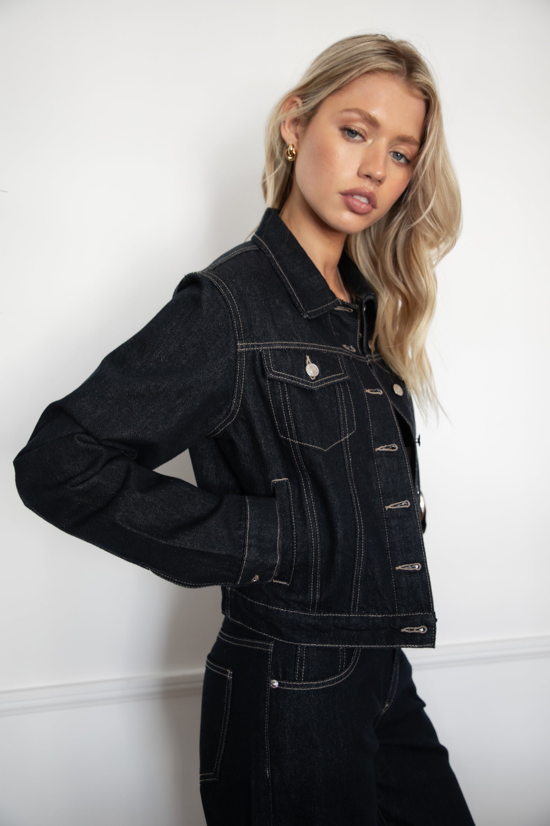 Model wearing TIC TOC TF31704 MILLS  selvedge denim jacket in dark blue wash with structured fit and contrast stitching with matching denim jeans in an indoor setting. 