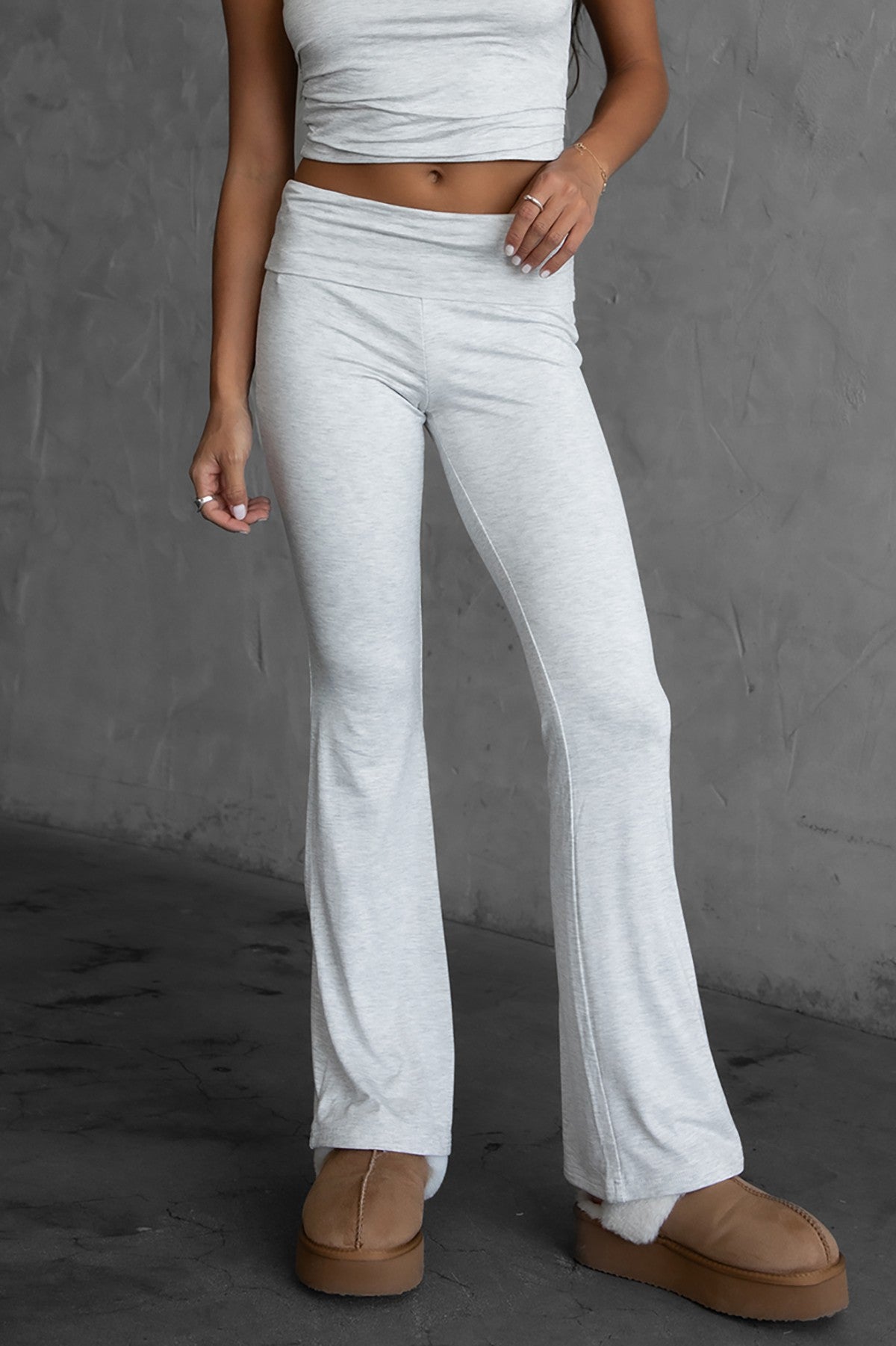 Woman wearing the TIC TOC PH30646BA CORA heather white fold over flare leggings featuring a low rise waistline, smooth stretch fabric, and subtle flare hem with matching top in a studio setting. 