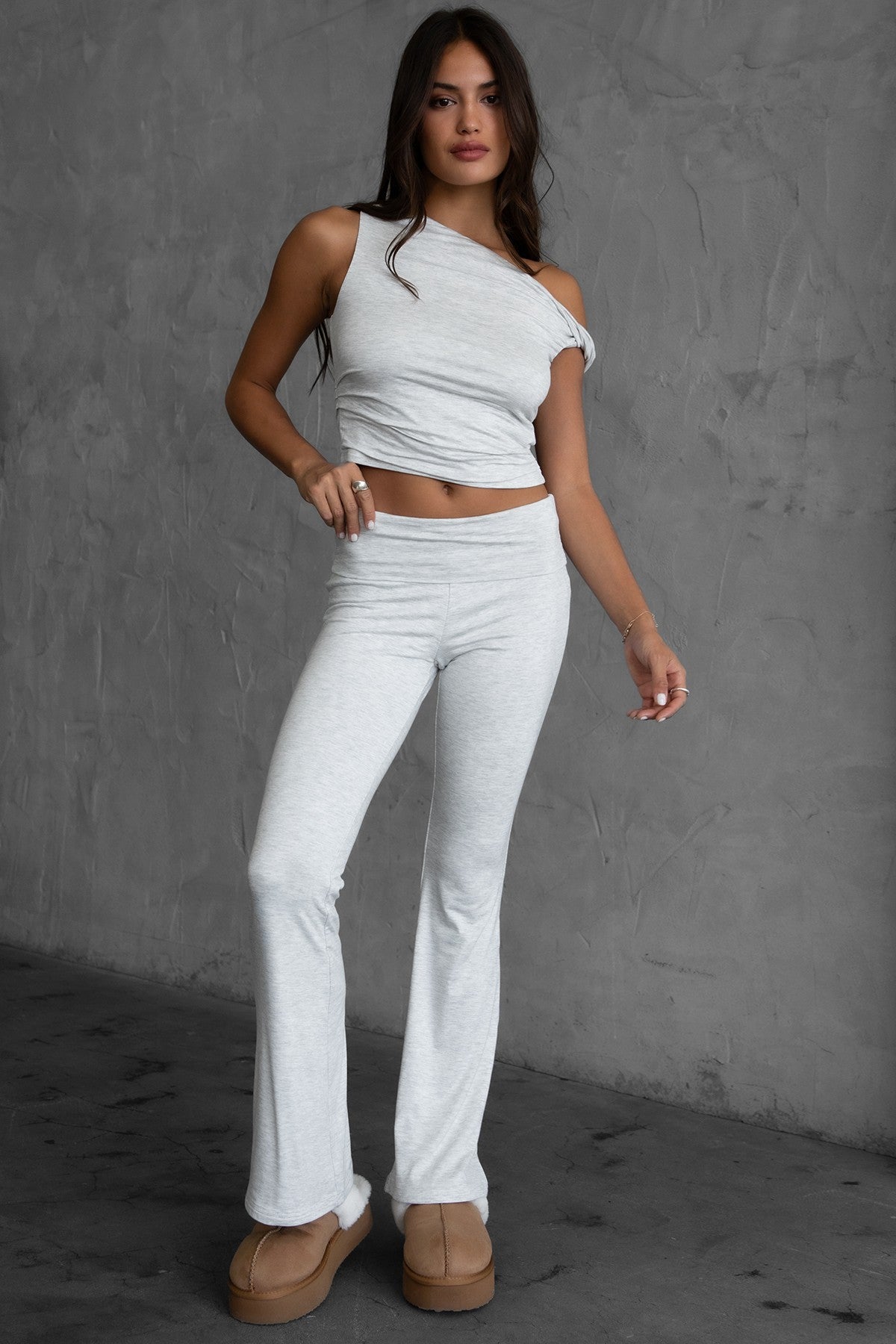 Woman wearing the TIC TOC PH30646BA CORA heather white fold over flare leggings featuring a low rise waistline, smooth stretch fabric, and subtle flare hem with matching top in a studio setting. 