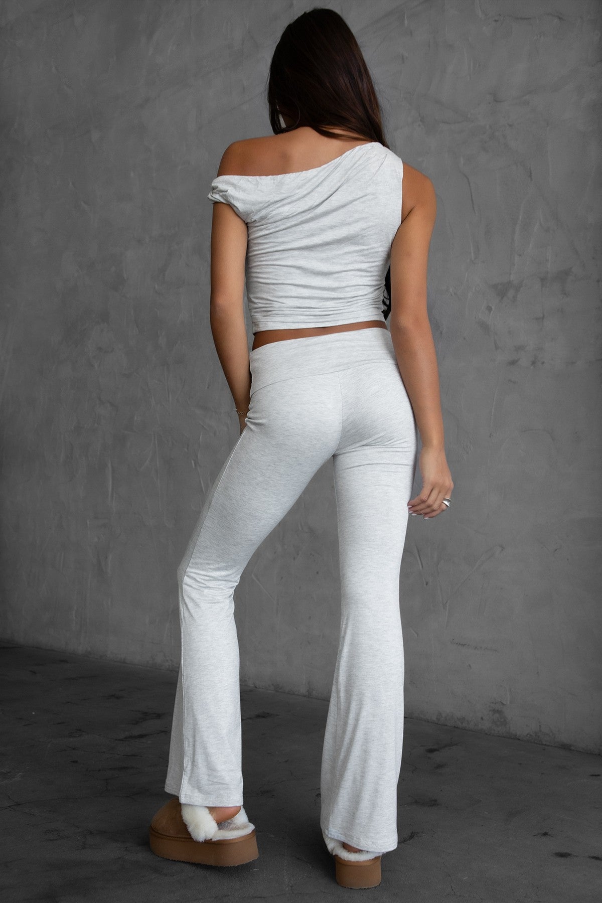 Woman wearing the TIC TOC PH30646BA CORA heather white fold over flare leggings featuring a low rise waistline, smooth stretch fabric, and subtle flare hem with matching top in a studio setting. 