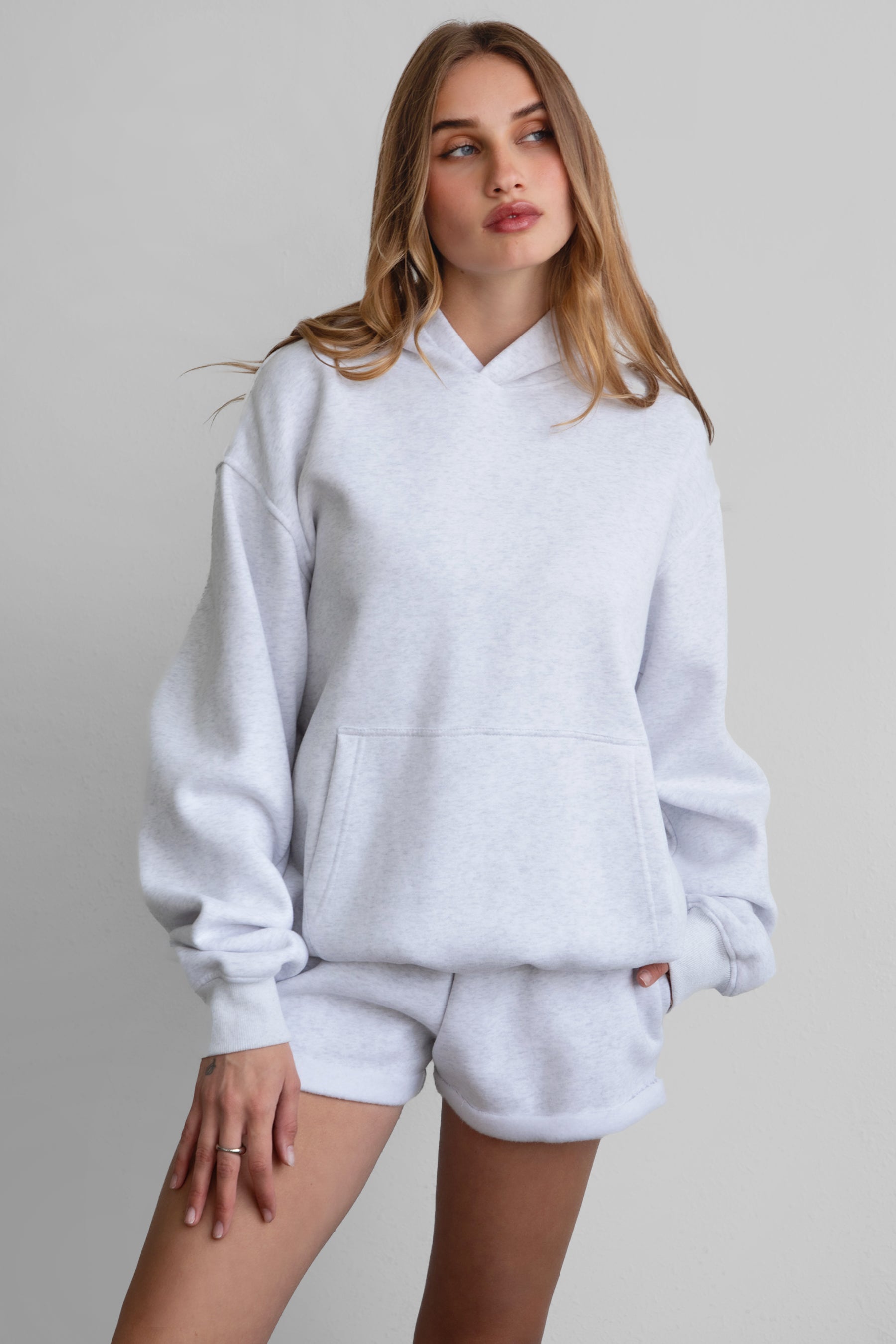 Woman wearing the TIC TOC TJ31007 DAMI ash cloud fleece oversized hoodie featuring a dropped shoulder design, kangaroo pocket, and ribbed cuffs with matching bottoms.