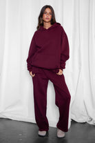 Woman wearing the TIC TOC TJ31007 DAMI black cherry cloud fleece oversized hoodie featuring a dropped shoulder design, kangaroo pocket, and ribbed cuffs with matching bottoms.