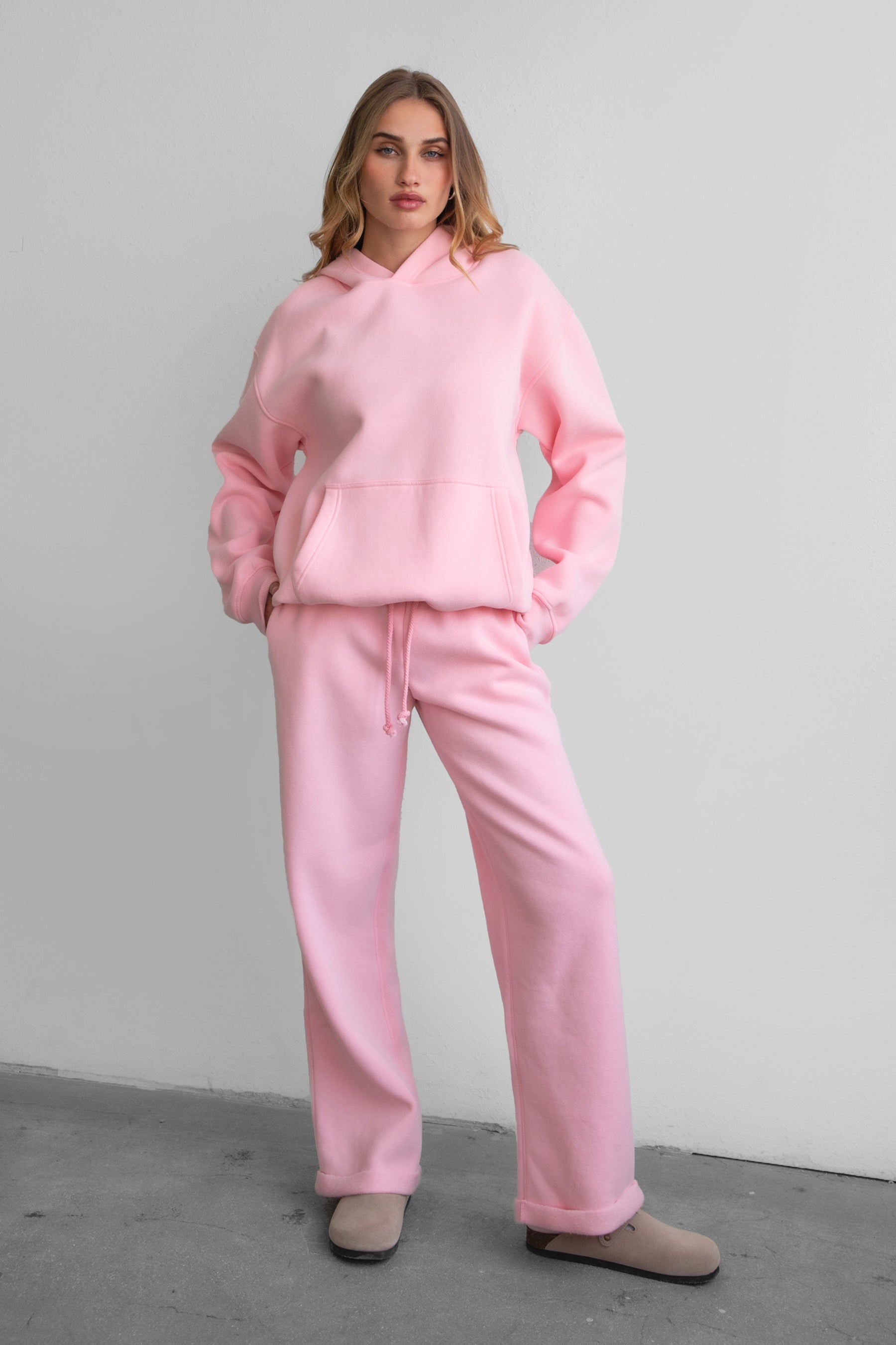 Woman wearing the TIC TOC TJ31007 DAMI blush cloud fleece oversized hoodie featuring a dropped shoulder design, kangaroo pocket, and ribbed cuffs with matching bottoms.