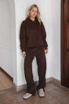 Woman wearing the TIC TOC TJ31007 DAMI dark brown cloud fleece oversized hoodie featuring a dropped shoulder design, kangaroo pocket, and ribbed cuffs with matching bottoms.
