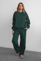 Woman wearing the TIC TOC TJ31007 DAMI forrest green cloud fleece oversized hoodie featuring a dropped shoulder design, kangaroo pocket, and ribbed cuffs with matching bottoms.