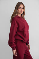 Woman wearing the TIC TOC TJ31007 DAMI maroon cloud fleece oversized hoodie featuring a dropped shoulder design, kangaroo pocket, and ribbed cuffs with matching bottoms.