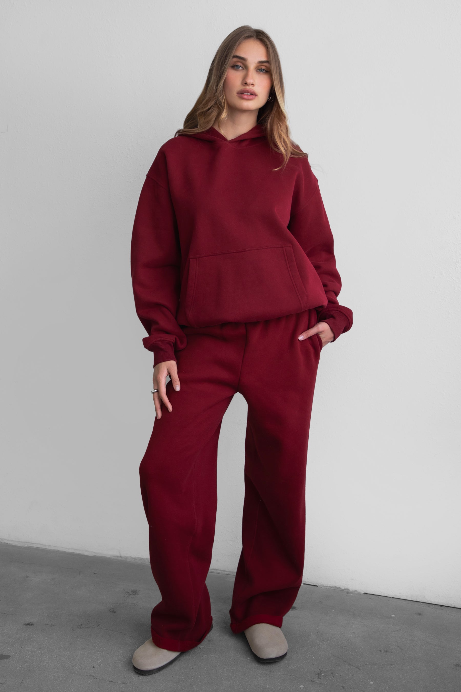 Woman wearing the TIC TOC TJ31007 DAMI maroon cloud fleece oversized hoodie featuring a dropped shoulder design, kangaroo pocket, and ribbed cuffs with matching bottoms.