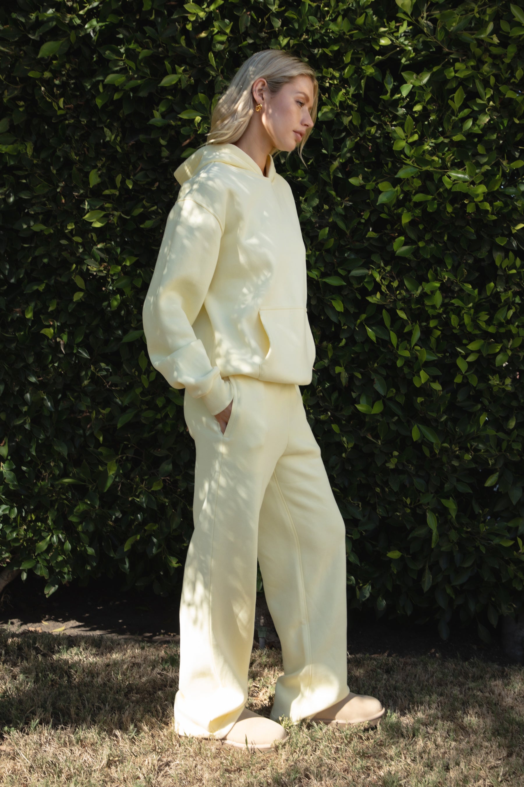 Woman wearing the TIC TOC TJ31007 DAMI pale yellow cloud fleece oversized hoodie featuring a dropped shoulder design, kangaroo pocket, and ribbed cuffs with matching bottoms.