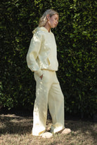 Woman wearing the TIC TOC TJ31007 DAMI pale yellow cloud fleece oversized hoodie featuring a dropped shoulder design, kangaroo pocket, and ribbed cuffs with matching bottoms.