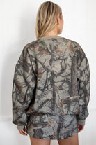 Woman wearing a camouflage outfit against a white background