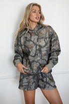 Woman wearing a camouflage outfit against a white background