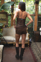 Woman wearing TIC TOC TL31345 SHANEA black embroidered beaded mesh cami top with sequin detailing and adjustable straps with brown suede shorts in a  room with vintage decor. 