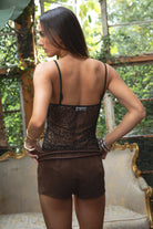 Woman wearing TIC TOC TL31345 SHANEA black embroidered beaded mesh cami top with sequin detailing and adjustable straps with brown suede shorts in a  room with vintage decor. 